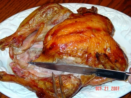Cut through the skin between leg and the body of the turkey